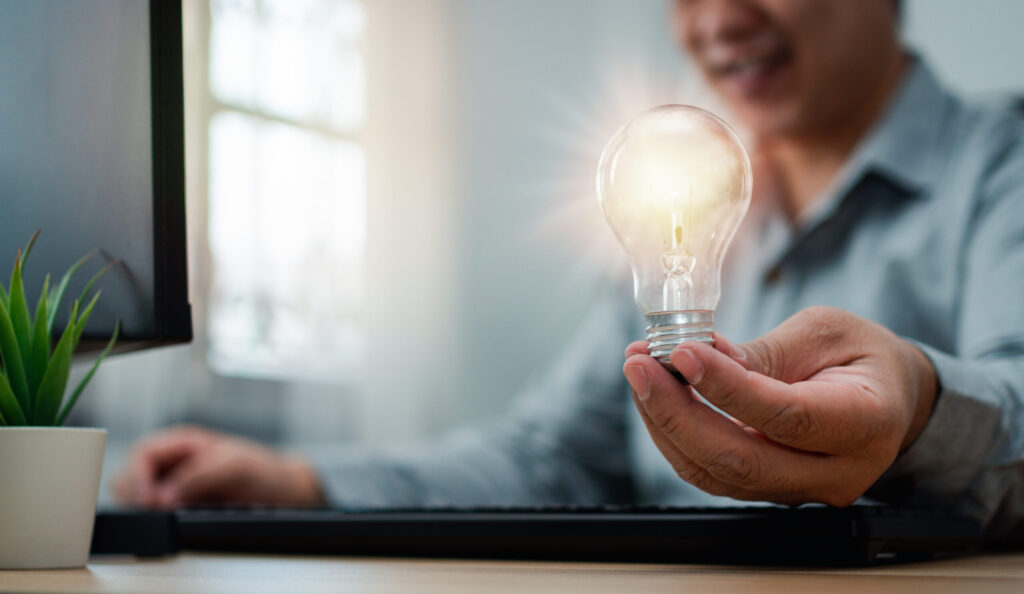 ひらめきを象徴する電球を手にする人物のイメージ写真（鹿児島まどか整体院ブログ用）