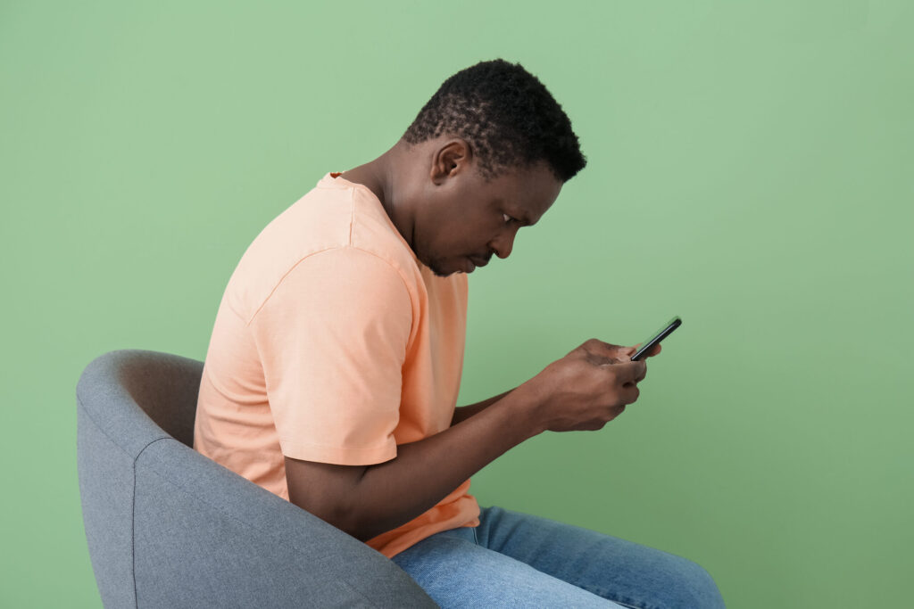 スマートフォンを見ながら前かがみになる男性の姿勢（鹿児島まどか整体院ブログ用）