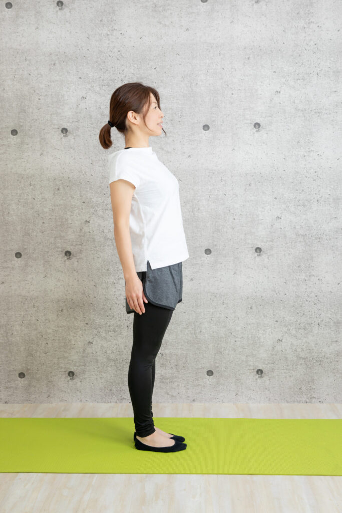 反り腰姿勢の女性の後ろ姿。腰が反っており、骨盤が前傾している状態。