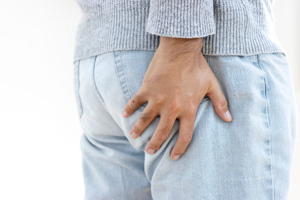仙骨・尾てい骨まわりに痛みを感じる女性がお尻を押さえている様子