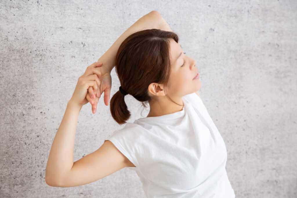 肩や背中を伸ばすストレッチをしている女性