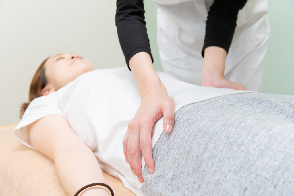 産後の骨盤まわりの状態をやさしく確認する整体の手技の様子